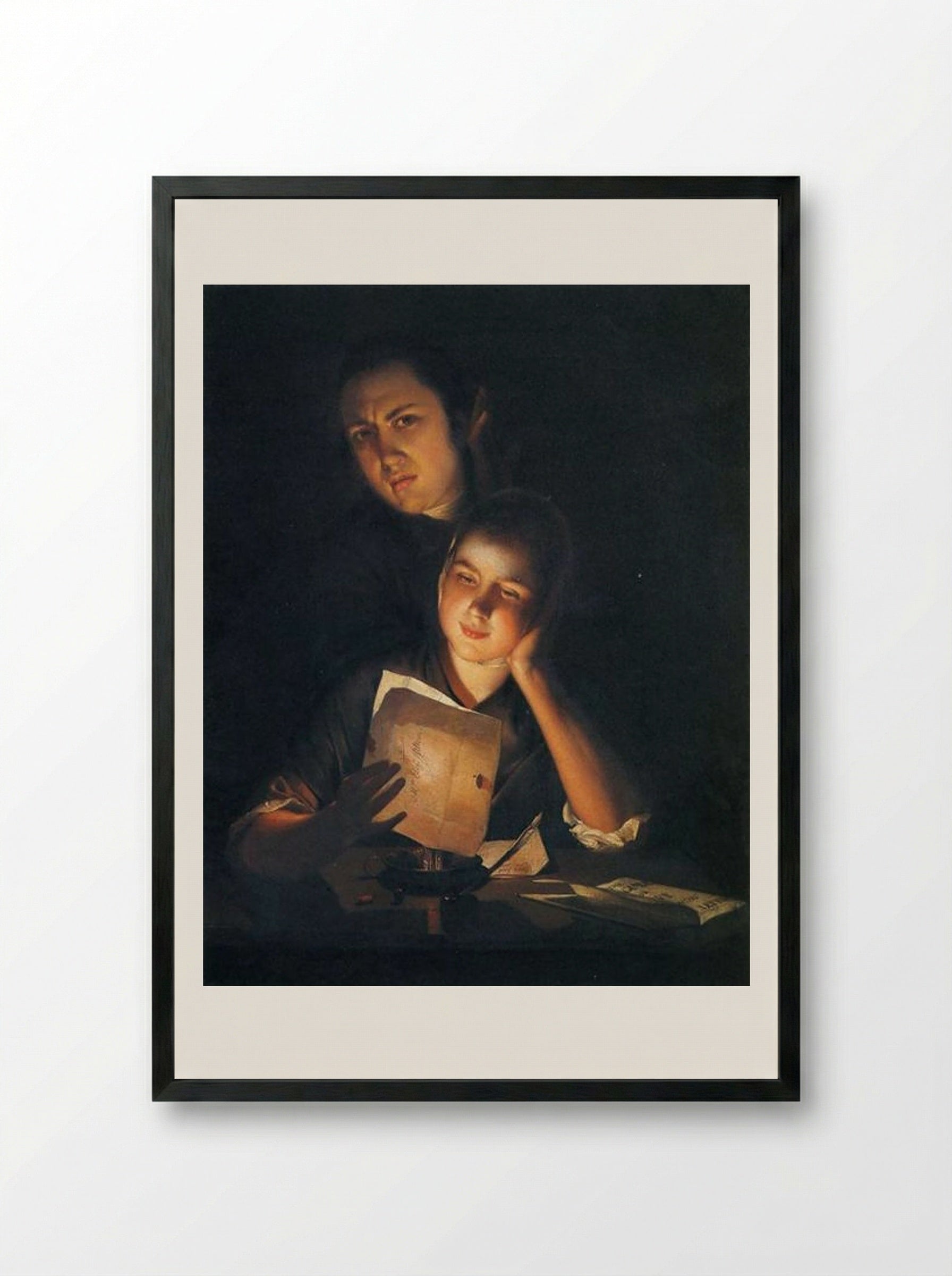 A Girl reading a letter by Candlelight, with a Young Man peering over her shoulder - Joseph Wright - Framed Print Black