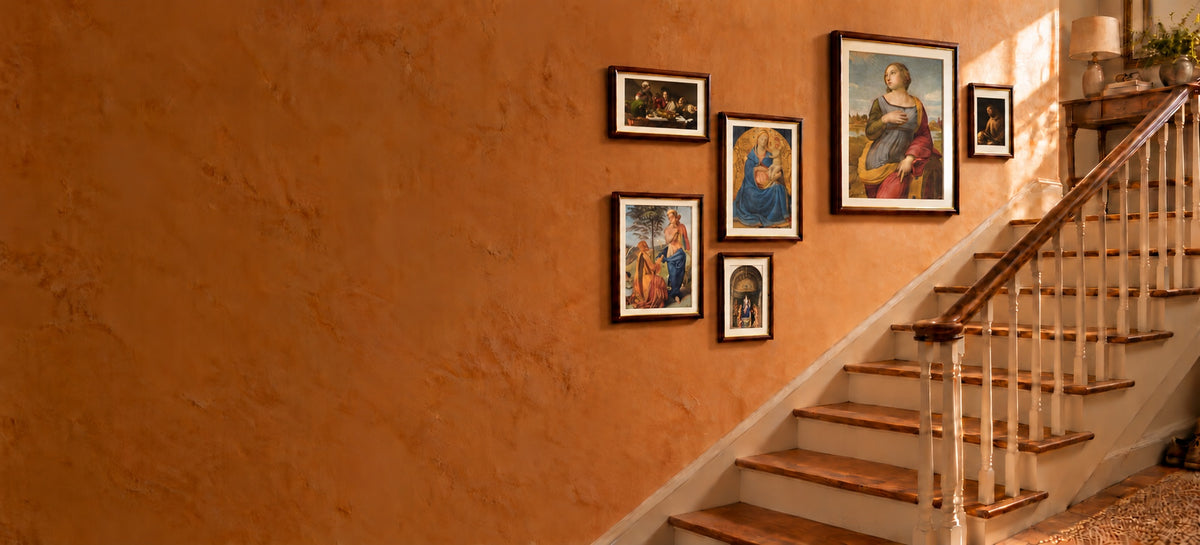 Staircase wall with six framed religious prints by Raphael, Fra Angelico, Caravaggio, Émile Bernard and Giovanni Bellini